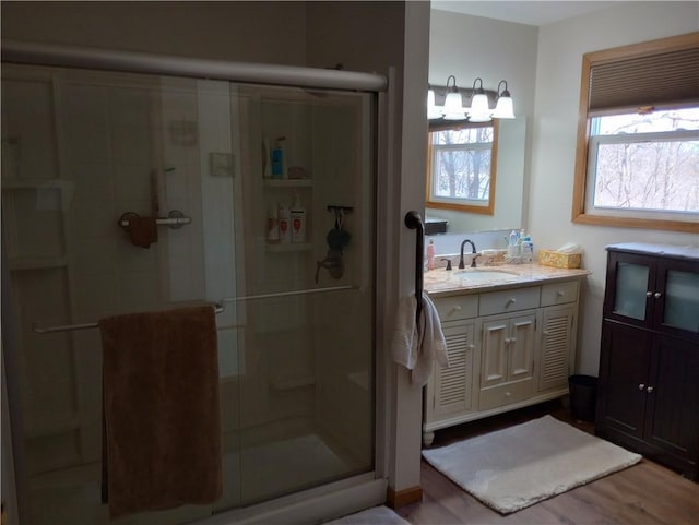 109 3rd St, Black River Falls, WI 54615 - bathroom featuring a stall shower, wood finished floors, and vanity