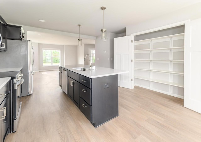 9120 Valley View Rd, Verona, WI 53593 - kitchen featuring appliances with stainless steel finishes, light wood-style flooring, an island with sink, and light countertops