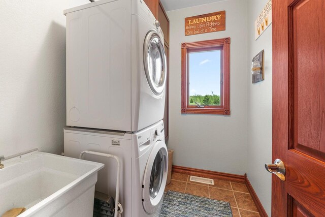 W5412 Bowe Ln, Fond Du Lac, WI 54937 - laundry area with stacked washer and clothes dryer, baseboards, and tile patterned flooring