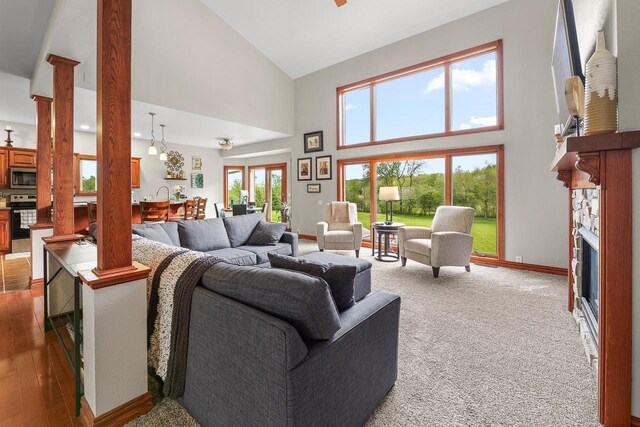 W5412 Bowe Ln, Fond Du Lac, WI 54937 - living room with decorative columns, high vaulted ceiling, a fireplace, baseboards, and wood finished floors
