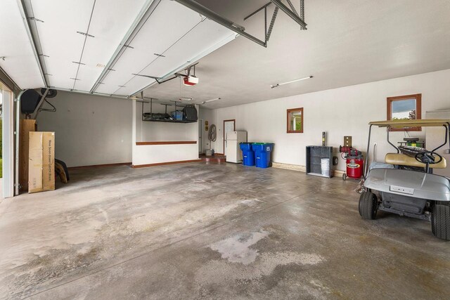 W5412 Bowe Ln, Fond Du Lac, WI 54937 - garage featuring freestanding refrigerator and a garage door opener