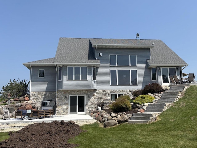 W5412 Bowe Ln, Fond Du Lac, WI 54937 - back of property with a patio area, stone siding, stairs, and a shingled roof