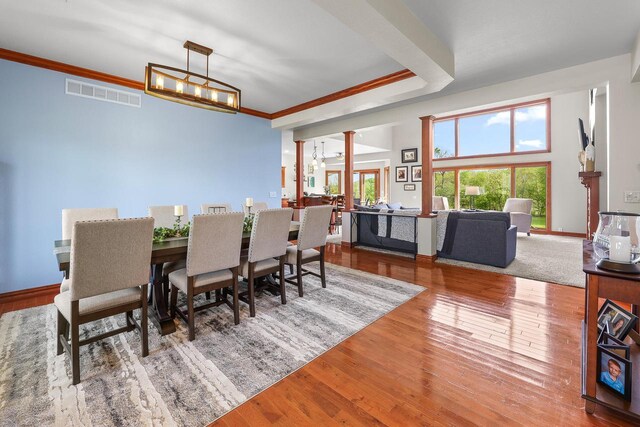 W5412 Bowe Ln, Fond Du Lac, WI 54937 - dining area with decorative columns, wood finished floors, crown molding, a chandelier, and baseboards