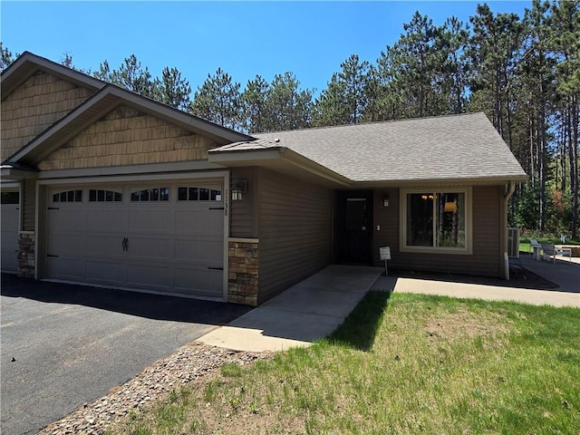 1138 23 1/2 St, Cameron, WI 54822 - view of front of home with an attached garage, stone siding, driveway, and roof with shingles