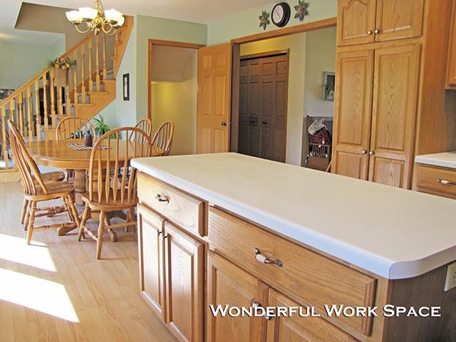1060 Kamla Ct, Platteville, WI 53818 - kitchen featuring light wood-style flooring, light countertops, a chandelier, and a kitchen island