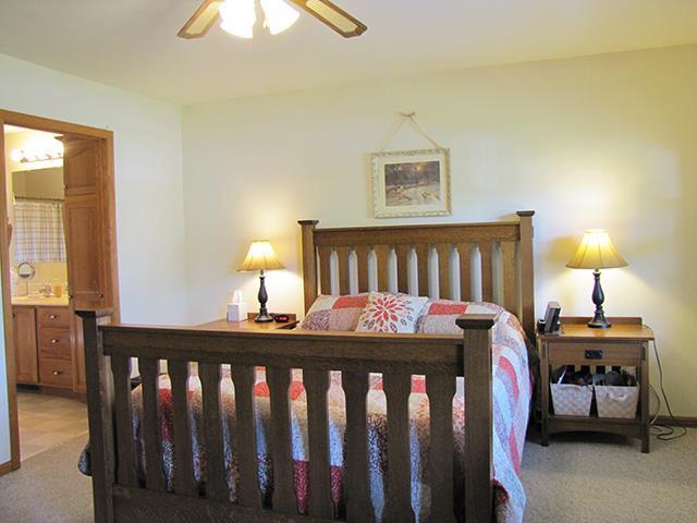1060 Kamla Ct, Platteville, WI 53818 - bedroom featuring light carpet, connected bathroom, and a ceiling fan