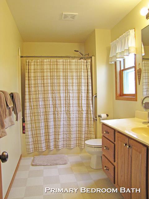 1060 Kamla Ct, Platteville, WI 53818 - bathroom with tile patterned floors, toilet, vanity, and shower / bathtub combination with curtain