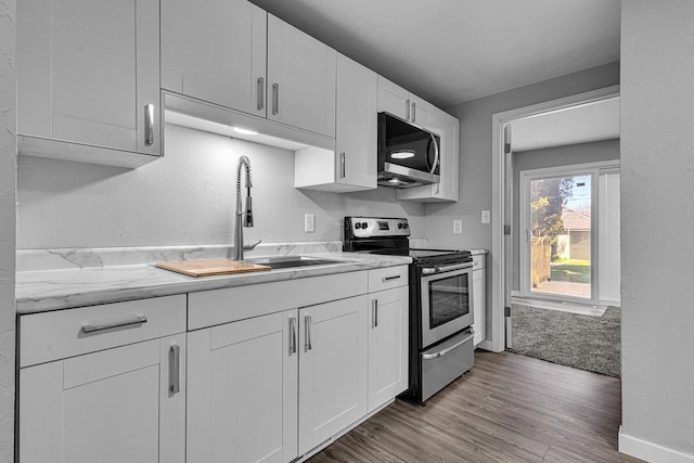 1629 Kentucky Ave, Sheboygan, WI 53081 - kitchen with stainless steel appliances, white cabinetry, light wood-style floors, and a sink