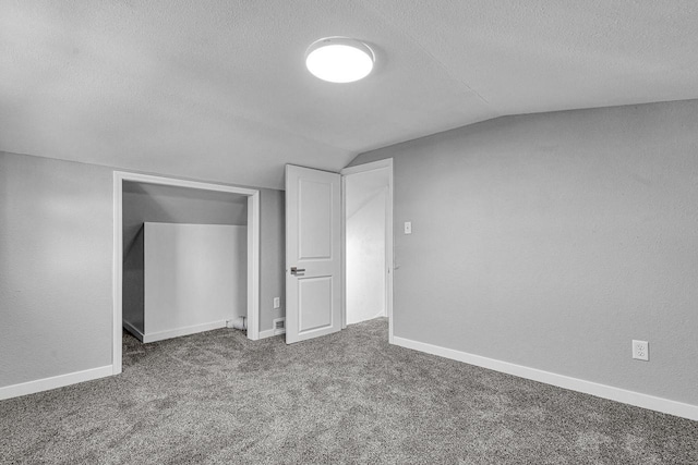 1629 Kentucky Ave, Sheboygan, WI 53081 - unfurnished bedroom featuring a textured ceiling, vaulted ceiling, carpet flooring, and baseboards
