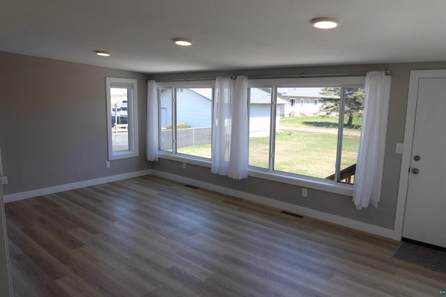 unfurnished room with baseboards and wood finished floors