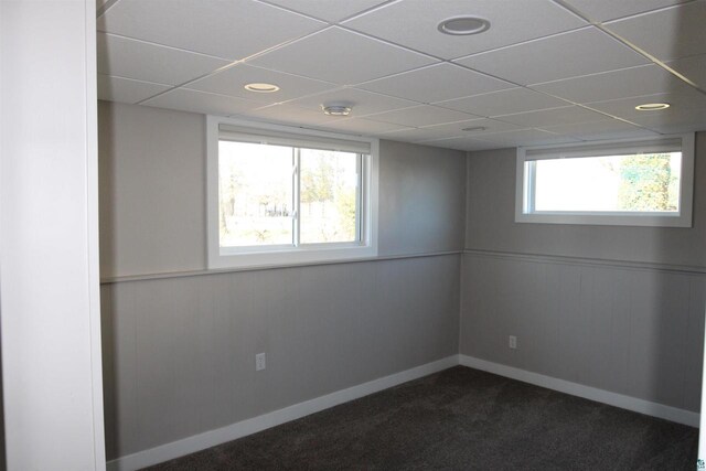 spare room with a paneled ceiling, a wainscoted wall, baseboards, dark colored carpet, and recessed lighting
