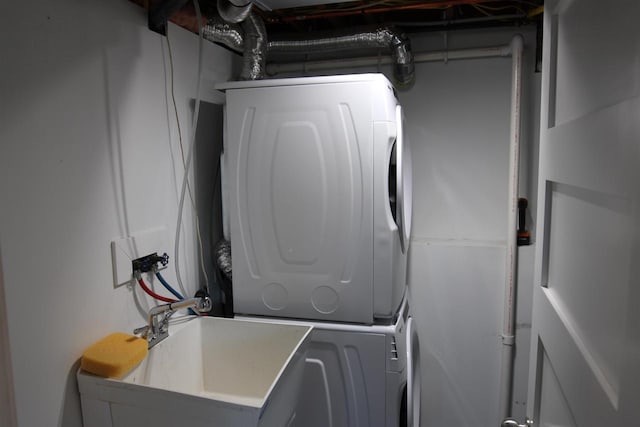 clothes washing area with stacked washer and clothes dryer