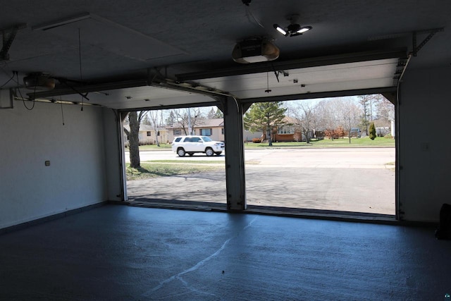 garage featuring a garage door opener and baseboards