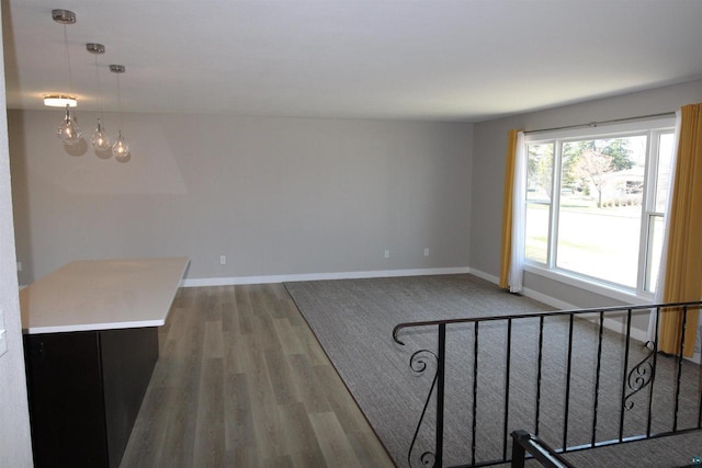 unfurnished living room featuring baseboards and wood finished floors