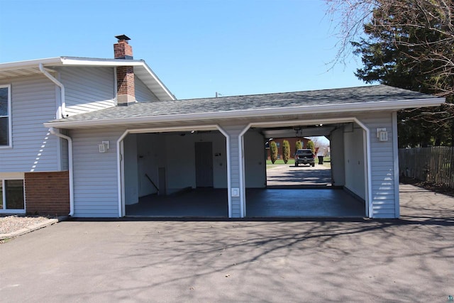 view of vehicle parking featuring fence and driveway