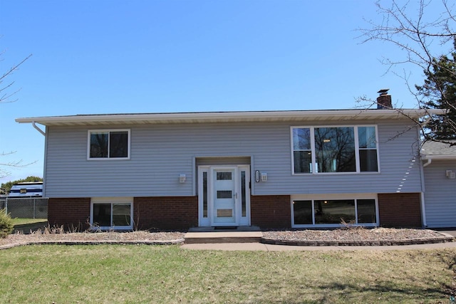 bi-level home with brick siding and a chimney