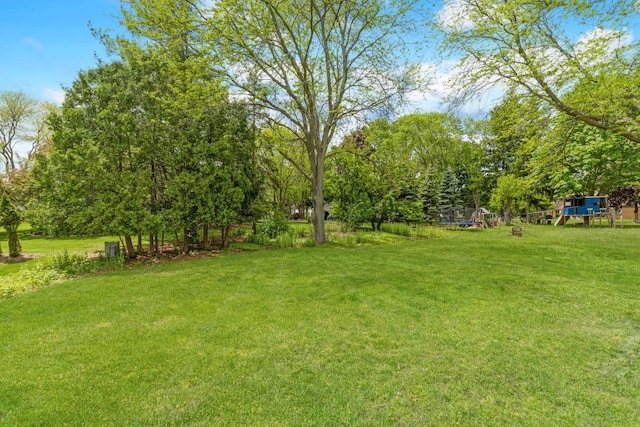 2845 Cambridge Cir, Brookfield, WI 53045 - view of grassy yard featuring a playground and a trampoline
