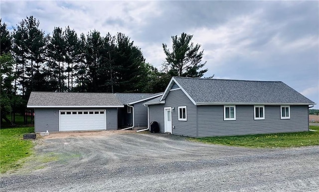 N16298 Fernwall Ave, Stanley, WI 54768 - view of front of home with a garage, an outbuilding, driveway, and a shingled roof