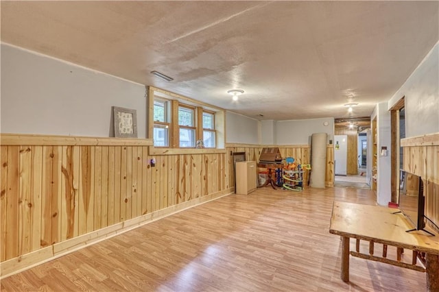 10148 Mcclaine Rd, Hayward, WI 54843 - living area featuring a wainscoted wall, wood finished floors, wooden walls, and a textured ceiling