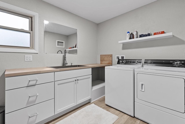 S58W22640 Glengarry Rd, Waukesha, WI 53189 - laundry room featuring independent washer and dryer, light wood finished floors, and cabinet space