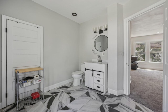 bathroom with baseboards, vanity, and toilet
