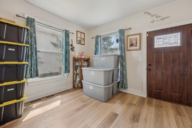entryway with wood finished floors and baseboards