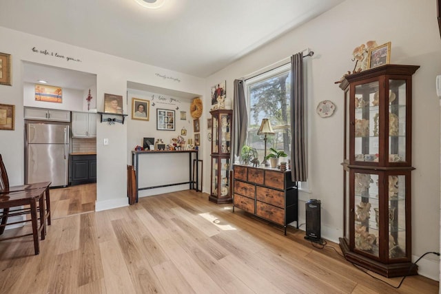 dining space featuring light wood-style floors and baseboards