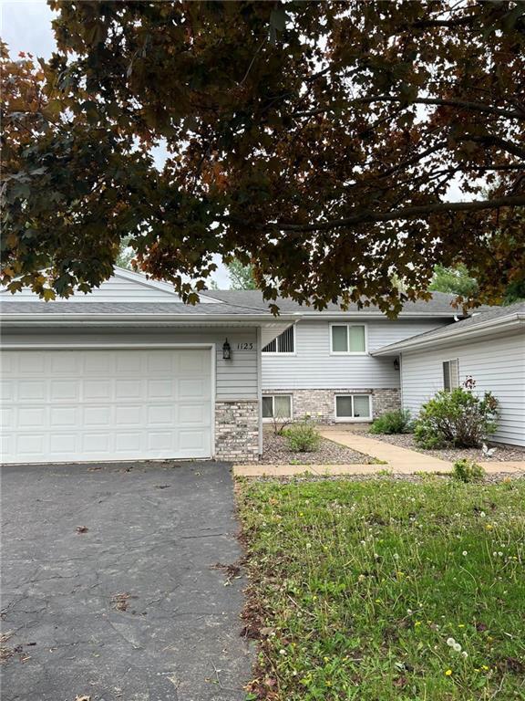 1123 Glades Dr, Altoona, WI 54720 - split level home with asphalt driveway, stone siding, and a garage