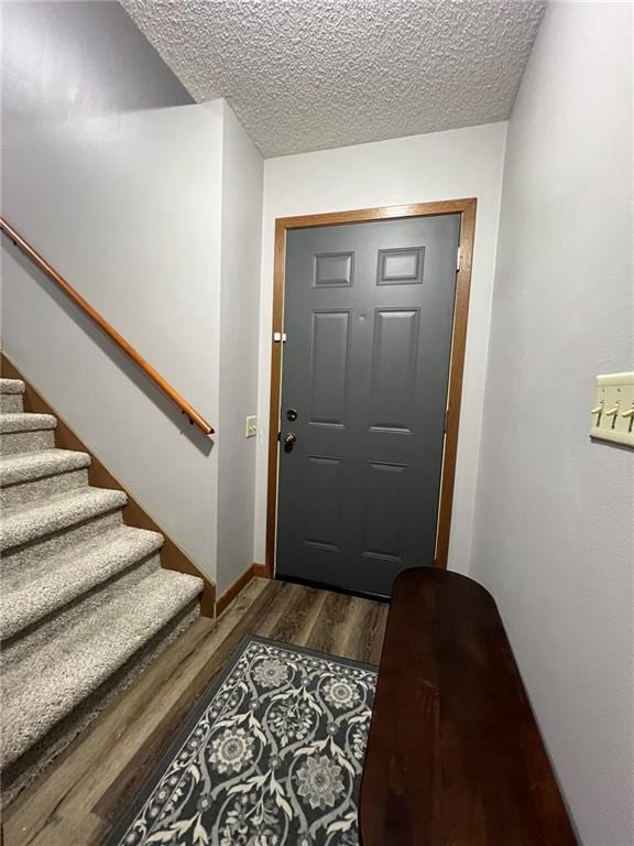 1123 Glades Dr, Altoona, WI 54720 - foyer entrance featuring stairs, a textured ceiling, dark wood finished floors, and baseboards
