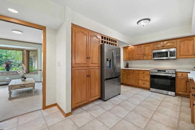 4330 Wilderness Dr, Mount Pleasant, WI 53403 - kitchen with stainless steel appliances, brown cabinets, light countertops, and light tile patterned floors