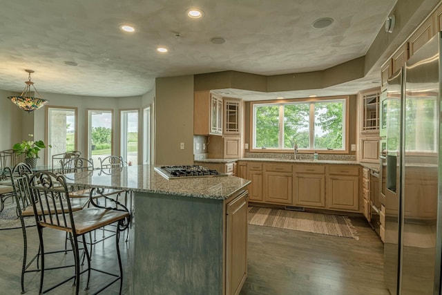 W6504 Klassy Rd, New Glarus, WI 53574 - kitchen with appliances with stainless steel finishes, light brown cabinetry, a sink, a kitchen breakfast bar, and a kitchen island