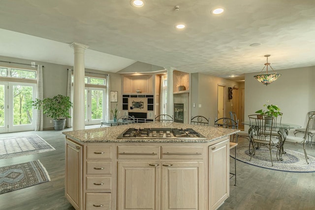 W6504 Klassy Rd, New Glarus, WI 53574 - kitchen with decorative columns, stainless steel gas stovetop, dark wood-style flooring, light stone countertops, and open floor plan