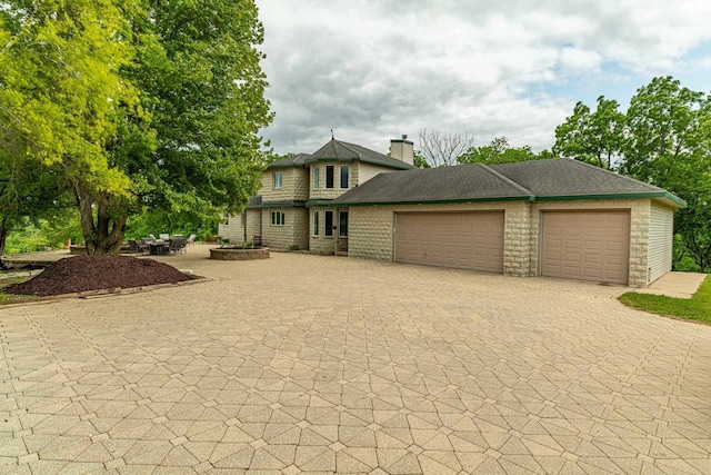 W6504 Klassy Rd, New Glarus, WI 53574 - view of front of property featuring decorative driveway, a garage, and a chimney