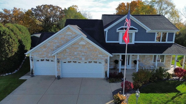 3929 Southwood Dr, Mount Pleasant, WI 53403 - view of front of home featuring stone siding, driveway, an attached garage, a porch, and a front yard