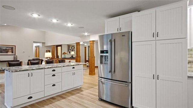 E3313 Jennifer Ln, Eau Claire, WI 54701 - kitchen with high end fridge, ornate columns, light wood-type flooring, white cabinetry, and light stone countertops