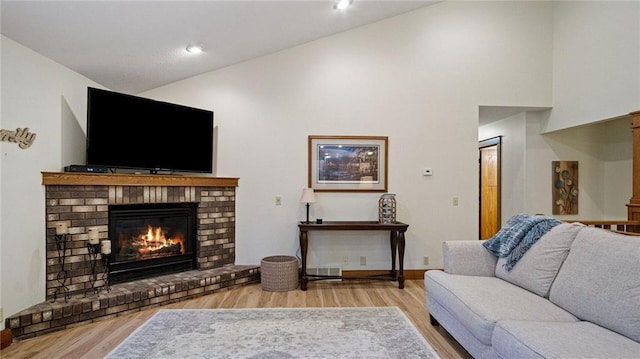 E3313 Jennifer Ln, Eau Claire, WI 54701 - living room featuring a brick fireplace, wood finished floors, high vaulted ceiling, and baseboards