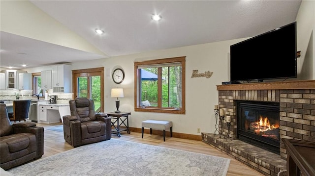 E3313 Jennifer Ln, Eau Claire, WI 54701 - living area featuring a fireplace, light wood-style flooring, vaulted ceiling, recessed lighting, and baseboards