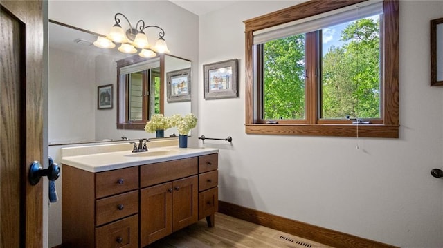 E3313 Jennifer Ln, Eau Claire, WI 54701 - bathroom with vanity, baseboards, wood finished floors, and a chandelier