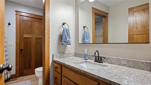 E3313 Jennifer Ln, Eau Claire, WI 54701 - bathroom with vanity, toilet, and wood finished floors