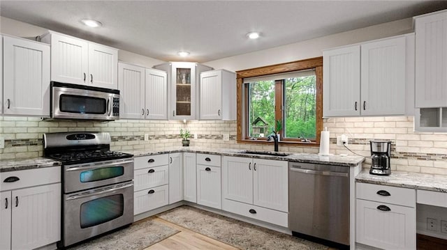 E3313 Jennifer Ln, Eau Claire, WI 54701 - kitchen featuring stainless steel appliances, a sink, white cabinetry, light stone countertops, and recessed lighting