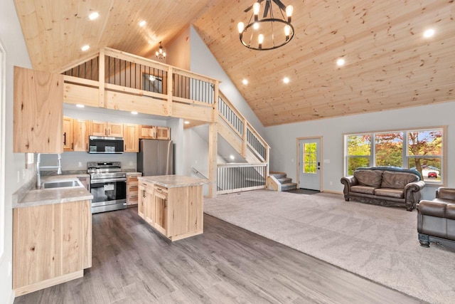 2806 3rd Ct, Oxford, WI 53952 - kitchen with stainless steel appliances, light brown cabinets, high vaulted ceiling, open floor plan, and a chandelier