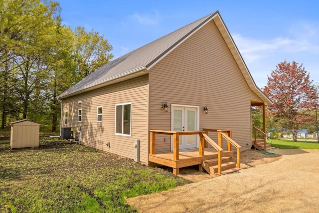 2806 3rd Ct, Oxford, WI 53952 - back of property featuring french doors, central AC, a storage unit, an outbuilding, and a deck