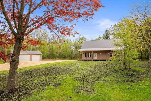 2806 3rd Ct, Oxford, WI 53952 - view of front of house with an outdoor structure, driveway, metal roof, a detached garage, and a porch