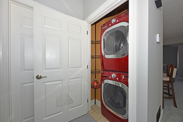 clothes washing area with estacked washer and dryer