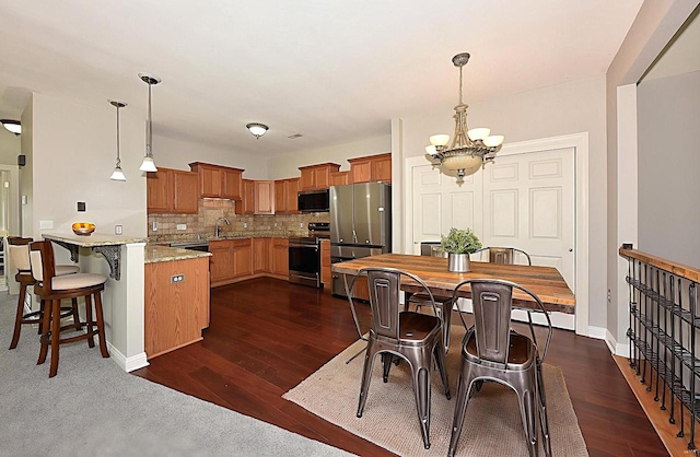 dining space with a chandelier, dark wood-style floors, and baseboards