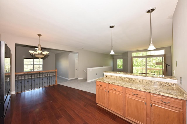 kitchen featuring a chandelier, dark wood-style floors, baseboards, and hanging light fixtures