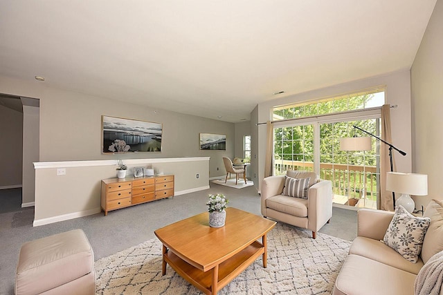 living room featuring light colored carpet and baseboards