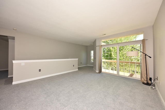 unfurnished living room featuring carpet flooring and baseboards