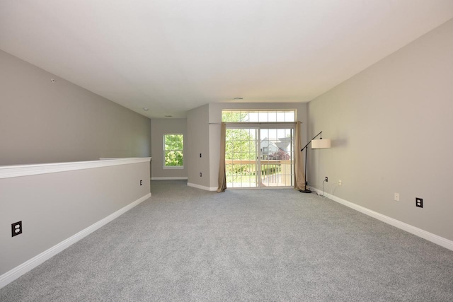 carpeted spare room featuring baseboards