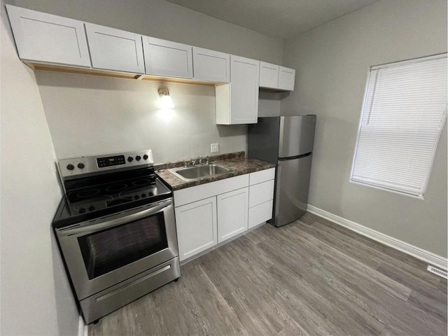 812 E Clarke St Unit 814, Milwaukee, WI 53212 - kitchen with stainless steel appliances, a sink, baseboards, light wood-style floors, and dark countertops